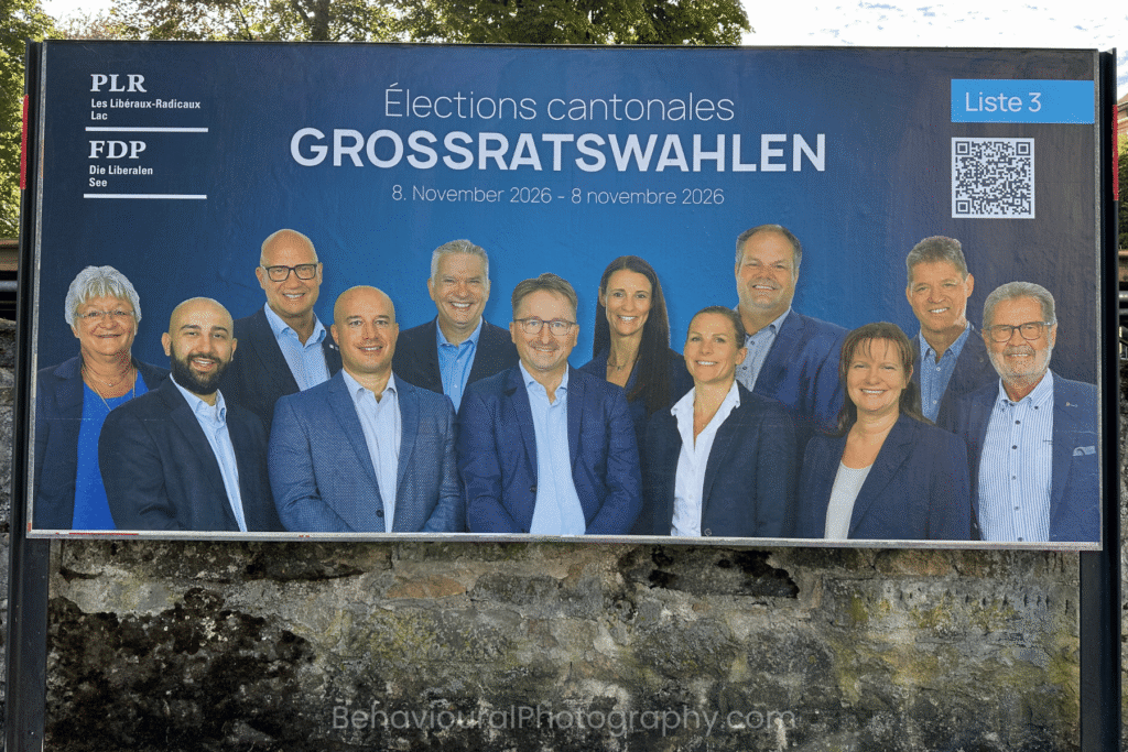 Swiss local election billboard featuring a group of political candidates of the PLR/FDP with a mixture of natural, awkward and forced-looking smiles, illustrating how facial expressions influence first impressions.